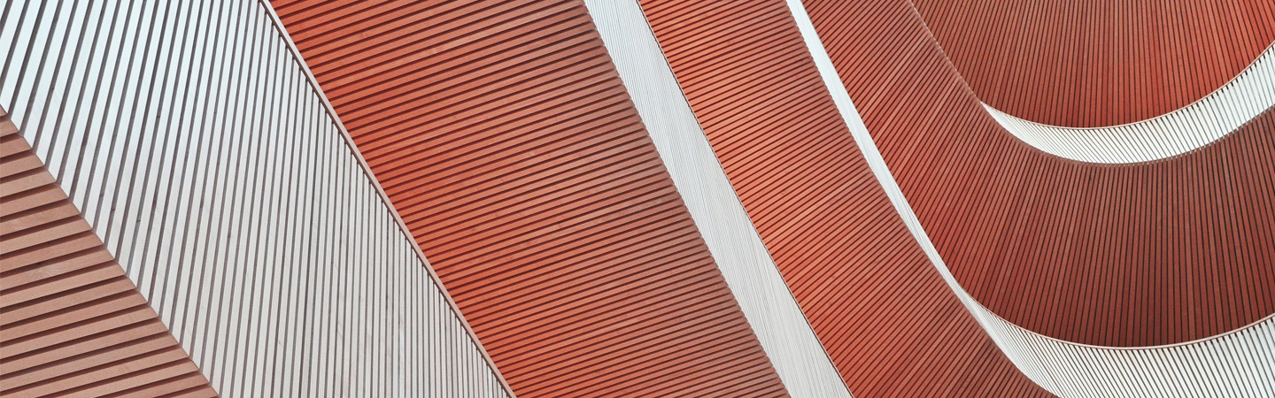 Abstract architectural detail showing curved terracotta-colored surfaces with geometric line patterns and white structural elements